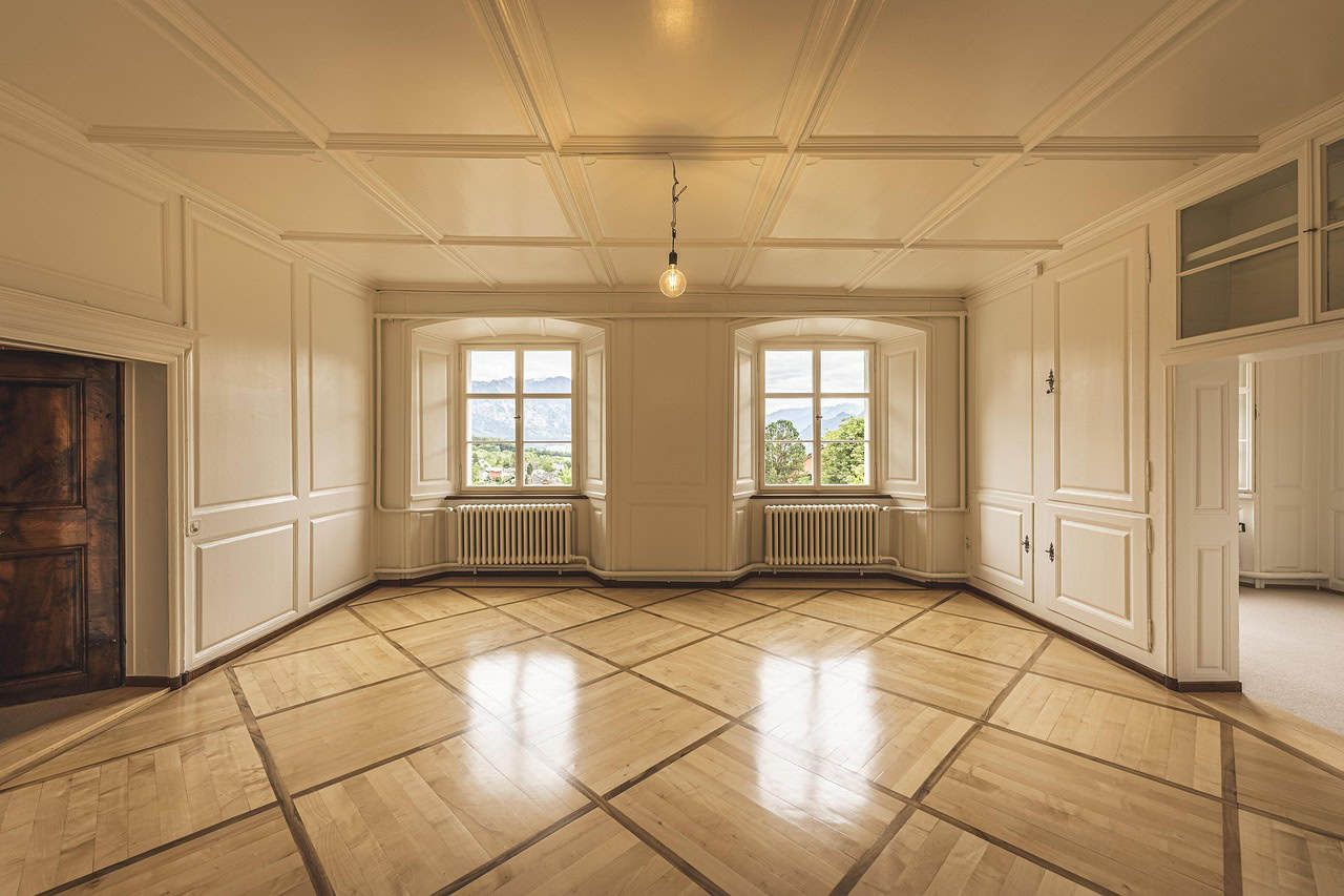 Bright spacious living room with large bay windows, elegant wood paneling, and detailed ceiling design, ideal for luxury homes in Vancouver, BC.