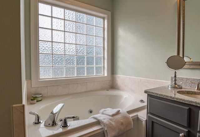 bathtub next to bathroom counter