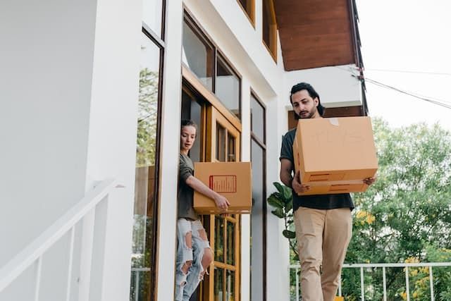 people carrying boxes out of house