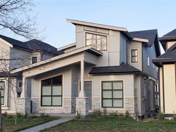 Modern contemporary home with stylish design, large windows, and inviting facade in a scenic residential neighbourhood in Vancouver, BC, representing prime real estate and quality craftsmanship.