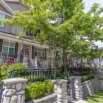 Modern townhouse row with inviting porch, landscaped gardens, and vibrant greenery in a desirable neighbourhood. Perfect for families looking for comfort and community.