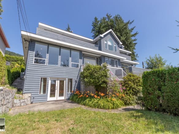 Spacious modern house with large windows and landscaped yard, ideal for real estate listings on Orca Realty Inc. in Vancouver.