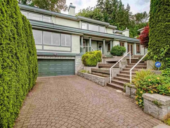 Spacious modern Vancouver home with landscaped front yard, concrete driveway, and outdoor stairs, offering excellent curb appeal and easy access for residents and visitors.