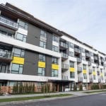 Modern multi-family residential building with contemporary design, featuring balconies, large windows, and colourful accents, ideal for Vancouver-based real estate investments and property management.
