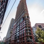 Contemporary high-rise condominium building in downtown Vancouver with modern architecture, glass balconies, and urban surroundings. Ideal for real estate investment and property management.