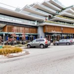 Modern multi-story condo building with retail storefronts on ground level in Vancouver, showcasing contemporary architecture and urban commercial space.
