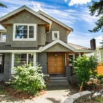 Charming modern house exterior with lush greenery and well-maintained landscaping in a suburban neighbourhood, showcasing Orca Realty Inc. property listings in Vancouver, BC.