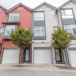 Modern multi-family townhouses with attached garages in a contemporary neighbourhood, showcasing vibrant brick and siding exteriors.
