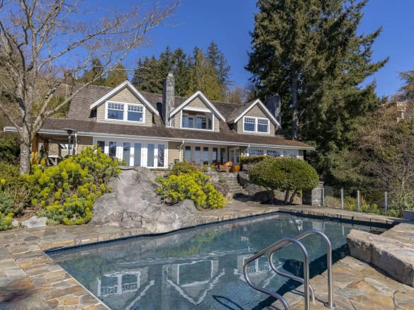 Stunning waterfront house with private swimming pool, landscaped garden, and forested hillside, ideal for luxurious real estate in Vancouver. Exceptional property by Orca Realty Inc. in BC.