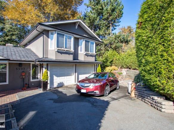 Modern two-story family home with attached garage and lush landscaping, located in a prime residential neighbourhood in Vancouver, British Columbia, perfect for families and outdoor living.