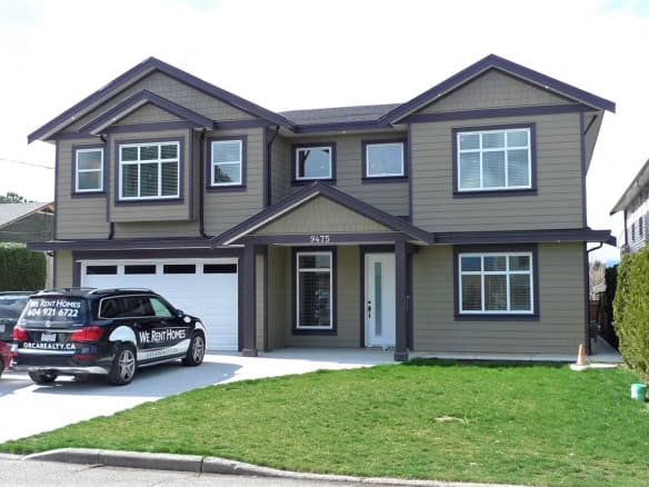 Spacious modern two-storey house for rent in Vancouver, BC by Orca Realty Inc., featuring a sleek exterior, large windows, and a landscaped lawn, perfect for families seeking quality rental homes.