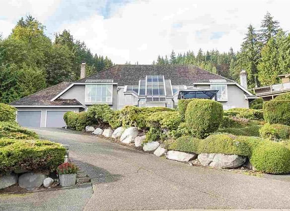 Spacious modern house with solar panels and landscaped garden, located in a lush, wooded area – ideal for luxury real estate buyers in BC.
