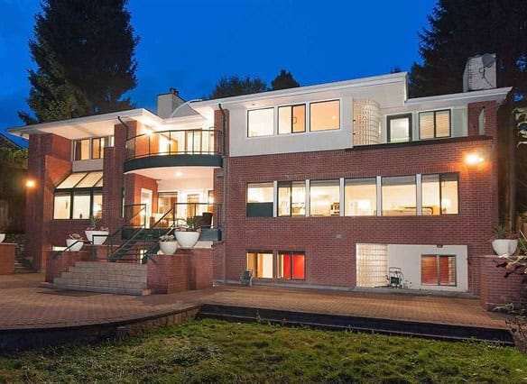 Luxury modern brick home exterior at dusk showcasing high-end residential design by Orca Realty Inc. in British Columbia, Canada.