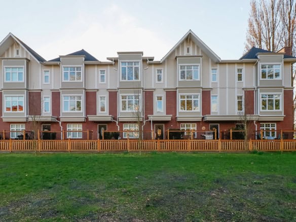 Modern multi-family residential building showcasing contemporary architecture, large windows, and a well-maintained yard, ideal for homebuyers and real estate investors in BC.