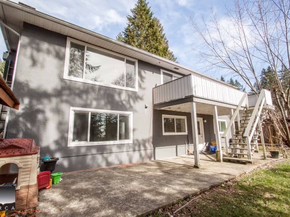 Spacious two-story home with modern exterior, large windows, and outdoor deck in a lush, wooded neighbourhood. Ideal for families seeking a peaceful, nature-centric lifestyle.