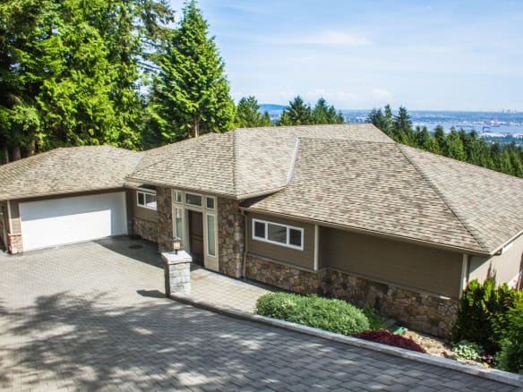Spacious single-family home with scenic views, lush greenery, and a paved driveway, ideal for Vancouver Island real estate investments and luxury residential properties.