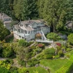 Aerial view of a large, modern house surrounded by lush greenery and colorful landscaping in a suburban neighbourhood in Vancouver, BC.