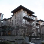 Contemporary residential building with modern architecture, stone accents, and spacious balconies in a Vancouver-area neighbourhood, ideal for real estate investment or luxury living.