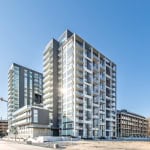 Contemporary modern high-rise residential building with glass balconies in Orca Realty Inc. property in Vancouver, BC. Luxurious urban living in a stylish, new condo development with scenic surroundings.