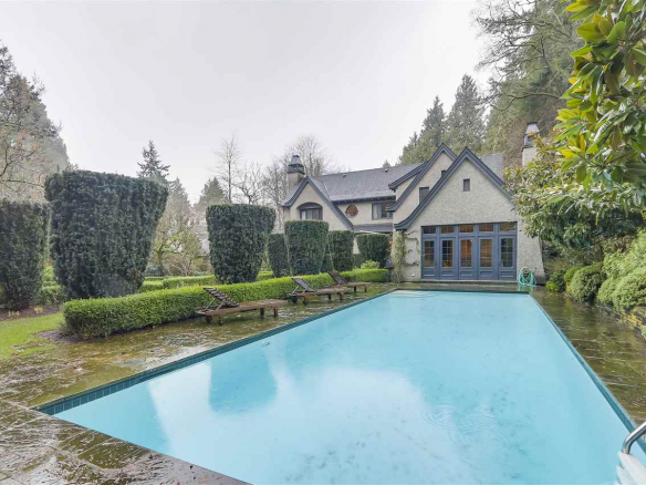 Luxury waterfront property with a private pool and lush landscaped gardens, offered by Orca Realty Inc., specializing in Vancouver Island real estate.
