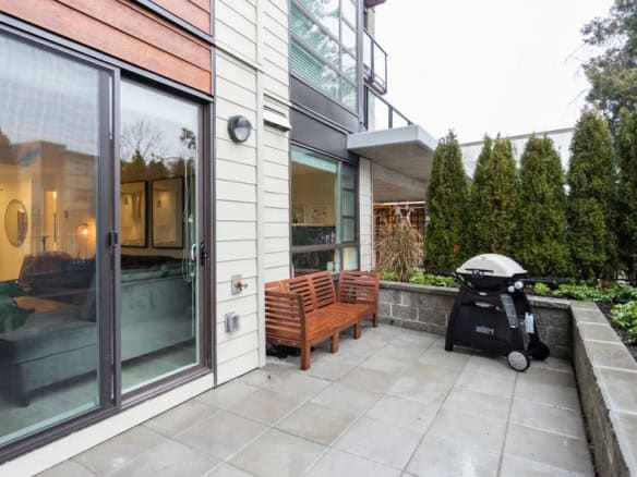 Modern apartment patio with seating and BBQ, ideal for Vancouver real estate buyers.