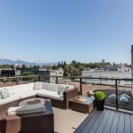Modern rooftop balcony with outdoor seating, overlooking the city skyline and mountains, perfect for relaxing or entertaining in Vancouver.