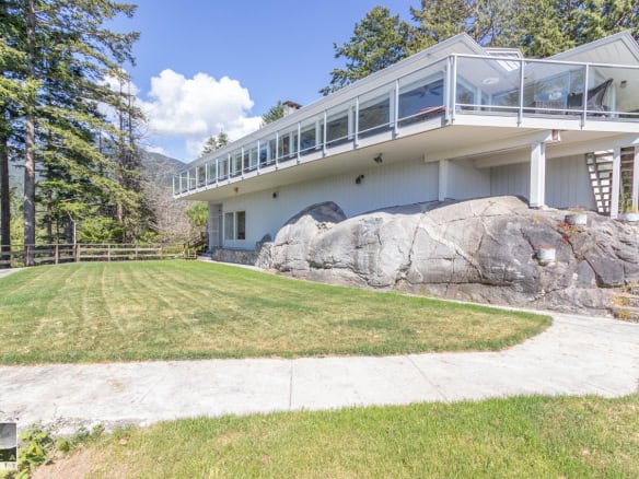 Spacious BC mountain home with large glass-enclosed balcony and scenic yard, perfect for family living and outdoor entertaining. Located in a peaceful natural setting.