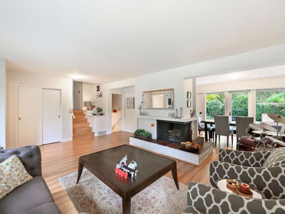 Modern interior living room with fireplace, large windows, and hardwood floors, showcasing Orca Realty Inc. expertise in Vancouver Island real estate market. Spacious, inviting, and perfect for families.