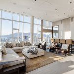 Luxurious high-rise living room with panoramic city and water views, modern furniture, and natural sunlight in Vancouver. Perfect for upscale real estate in British Columbia.
