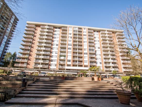 Modern waterfront condominium building in Vancouver, BC showcasing luxury apartment living with spacious balconies and scenic views, ideal for real estate investment or homeownership.