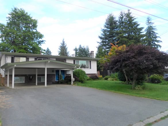 Spacious family home with a well-maintained front yard, mature trees, and a covered carport in a peaceful neighbourhood, ideal for real estate investment or family living.