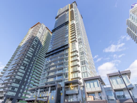 Modern high-rise condominium building in Vancouver's downtown core with glass facades and spacious balconies, representing luxury real estate in British Columbia.
