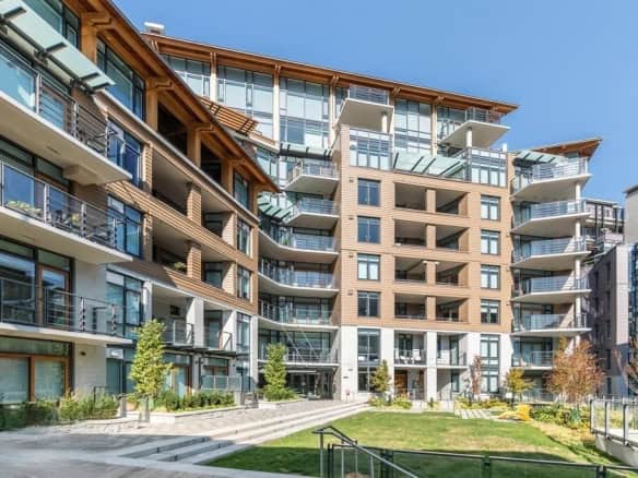 Modern multi-storey apartment building with balconies and large windows in an urban setting, showcasing contemporary architecture.