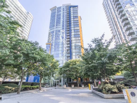 Sleek modern high-rise apartment building in downtown Vancouver with lush greenery and landscaped surroundings, perfect for urban residential living in BC.