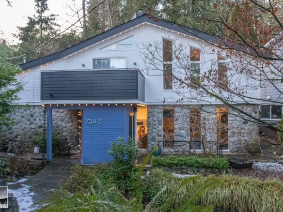 Contemporary house with stone and wood exterior, surrounded by lush greenery and trees, for sale by Orca Realty Inc. in Victoria, BC. Perfect family home in a peaceful neighbourhood.