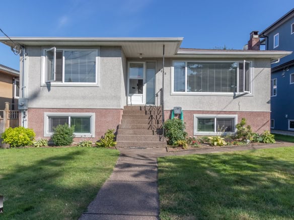 Charming, well-maintained two-story residential home with front stairs, lush lawn, and manicured flower beds, showcased by Orca Realty Inc. in a friendly neighborhood.