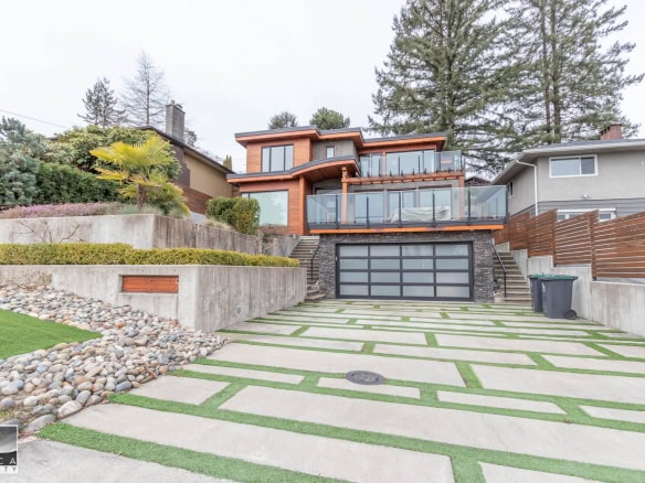 Contemporary multi-level house with large glass balconies, modern design, and landscaped front yard in Vancouver, BC. Perfect for luxury real estate buyers seeking stylish and spacious homes.
