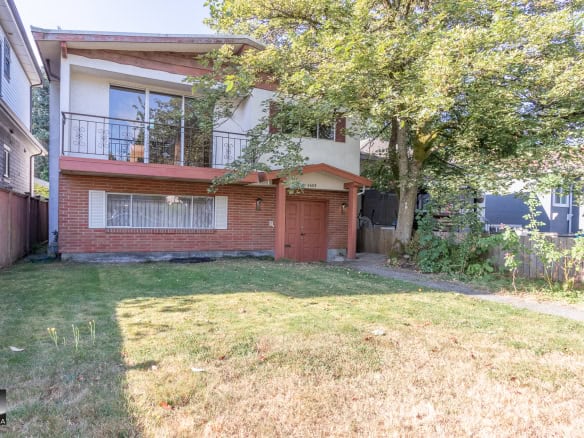 Charming multi-family home with a inviting brick facade, spacious backyard, and lush tree canopy, located in a desirable neighborhood—ideal for buyers seeking a cozy residence in Vancouver.