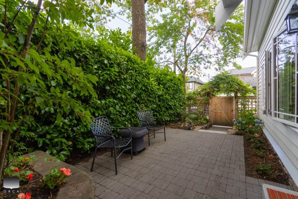 Secluded backyard patio with garden and outdoor seating, perfect for relaxing or entertaining - ideal for Vancouver Island homebuyers.