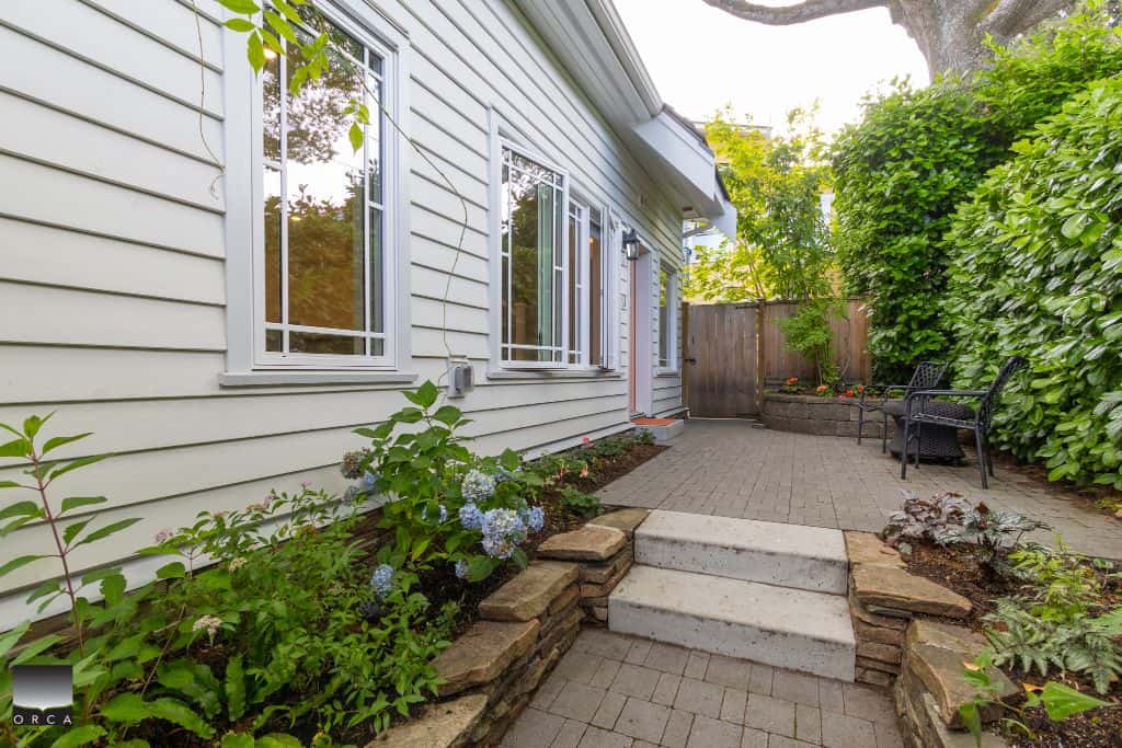 Serene backyard patio with lush greenery, perfect for relaxing and outdoor entertaining in Vancouver. Well-maintained garden, stone pathway, and cozy seating area enhance the home's appeal.