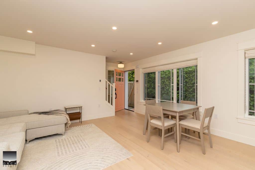 Bright and inviting living room and dining area in a modern Vancouver home, featuring large windows, neutral decor, and hardwood floors, ideal for contemporary BC real estate buyers.