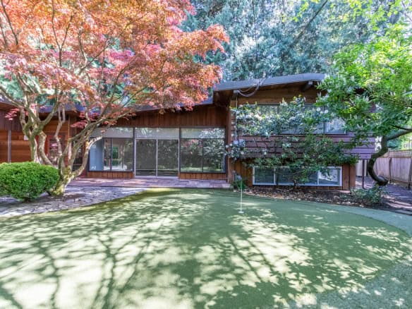 Charming private backyard of a modern residential home with lush trees, vibrant landscaping, and a well-maintained yard, perfect for outdoor living and entertaining in Vancouver.