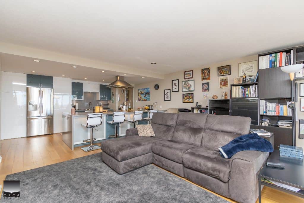 Spacious modern living room with open-concept kitchen, stainless steel appliances, and stylish decor in Vancouver, BC. Perfect for families and professionals seeking Vancouver real estate.