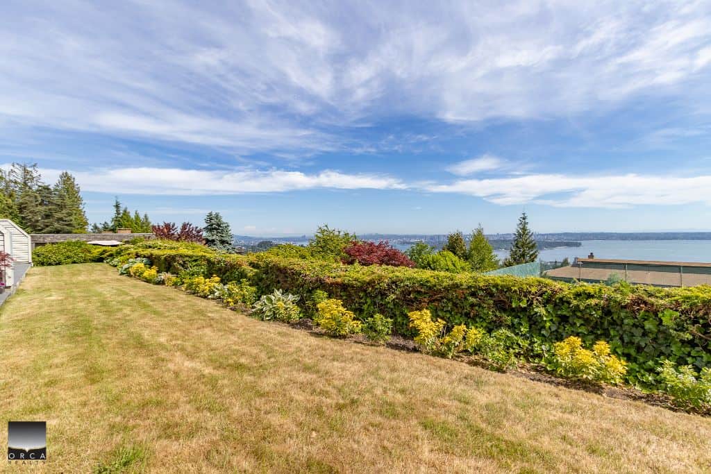 Expansive backyard with lush landscaping and ocean view, ideal for outdoor living and entertaining in Victoria, BC. Perfect for real estate listings showcasing scenic outdoor spaces.