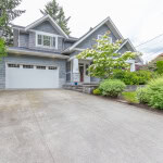 Spacious family home with a landscaped front yard and modern exterior, available through Orca Realty Inc., Vancouver Island real estate experts.
