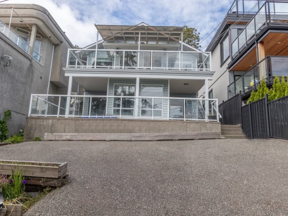 Bright modern multi-level waterfront house with extensive glass balconies and open rooftop patio, featuring contemporary architecture and prime ocean views, listed by Orca Realty Inc.