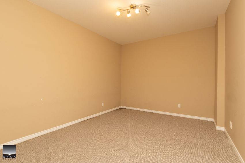 Spacious empty room with beige walls and neutral carpeting, ideal for a home or apartment property listing in Ottawa, Ontario.