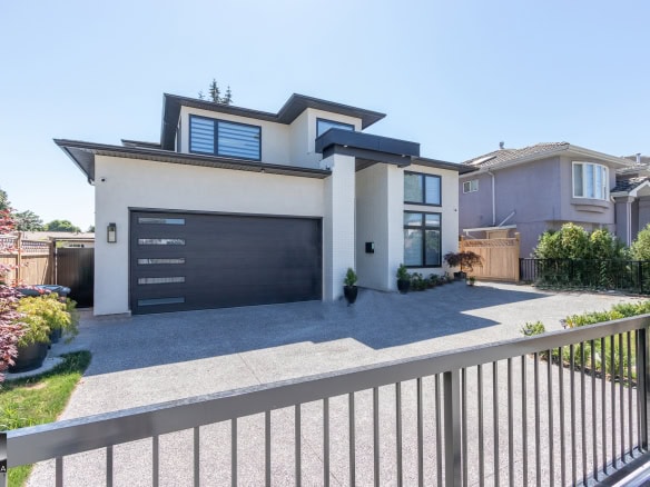Contemporary modern house with sleek exterior design, large windows, and spacious driveway, located in a desirable neighbourhood—expert real estate services by Orca Realty Inc.