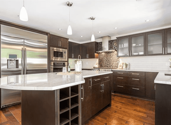 Stunning modern kitchen with stainless steel appliances, dark wood cabinets, and an island for cooking and entertaining. Perfect for homebuyers seeking contemporary Vancouver Island homes.