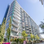 Contemporary waterfront condominium building in Vancouver, BC with glass balconies and lush landscape. An ideal location for luxury real estate and urban living in British Columbia.